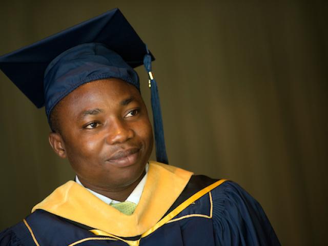A student wears a cap and gown.